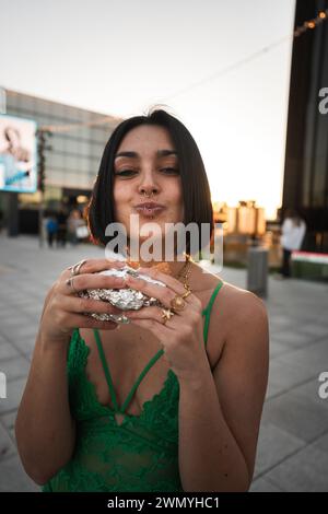 Una donna elegante si gode il tramonto a Madrid con le iconiche quattro Torri sullo sfondo, che mostrano la vita urbana spagnola. Foto Stock