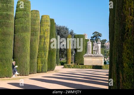 Una fila di siepi di cipresso nei giardini e il vicino monumento del primo re e regina di Spagna, Ferdinando 11 d'Aragona e Isabella i di Castiglia Re Foto Stock