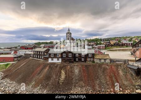 Qui è esposto il paesaggio storico di Roros, con la sua chiesa prominente e le tradizionali case in legno annidate nelle dolci colline della Norvegia Foto Stock