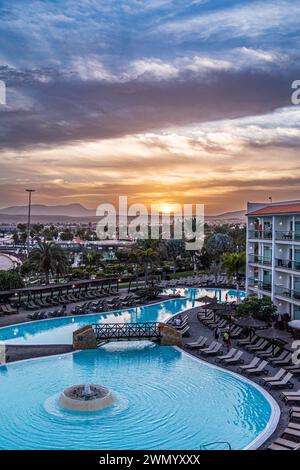 Il sole che tramonta dietro le colline visto dal Barcelo Fuertentura Mar Hotel a Caleta de Fuste sull'isola Canaria di Fuerteventura, Spagna Foto Stock