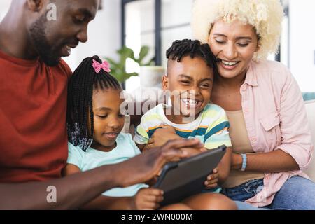 Padre e figlio afroamericani con una giovane madre e figlia birazziale condividono un momento di gioia Foto Stock