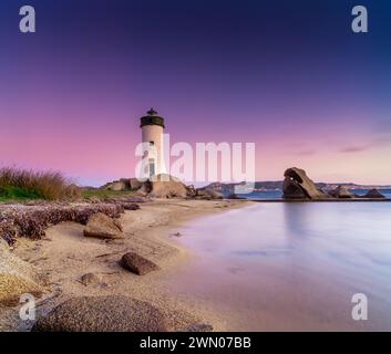 Vista a lunga esposizione del faro di Punta Palau sulla Costa Smeralda della Sardegna all'alba Foto Stock