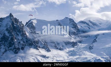 Un parapendio con il Monte bianco (a destra) e l'Aguille du Midi (a sinistra), vicino a Chamonix, Francia. Foto Stock