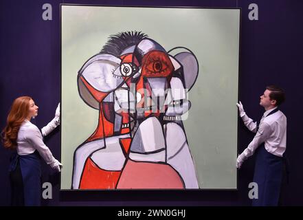 Londra, Inghilterra, Regno Unito. 28 febbraio 2024. I membri dello staff di Sotheby detengono George Condo's Red, Green and Gray Head, stimato a 1.500.000 - 2.000.000 GBP durante l'anteprima delle prime aste di arte moderna e contemporanea di Sothebys del 2024. (Credit Image: © Thomas Krych/ZUMA Press Wire) SOLO PER USO EDITORIALE! Non per USO commerciale! Foto Stock