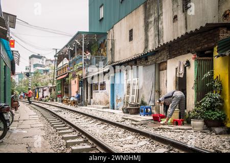 La gente del posto vive la vita quotidiana sulla via dei treni di Hanoi, in Vietnam Foto Stock