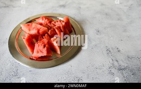 Una foto ravvicinata di succose fette di anguria disposte su una piastra di metallo Foto Stock