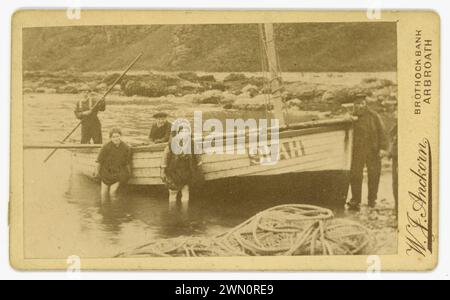 La carte de visite vittoriana originale (biglietto da visita o CDV) di una famiglia di pescatori che lancia una barca da pesca (registrata come 91 AH) ad Auchmithie, luogo di nascita del famoso Arbroath Smokie - eglefino affumicato, barche più piccole come questa venivano utilizzate per la pesca di granchi e aragoste. Dal fotografo scozzese W J Anckorn di Arbroath (studi presso Brothock Bridge e Brothock Bank), Scozia, Regno Unito circa 1880 Foto Stock