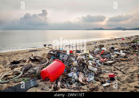 Koh Samui, Thailandia - 19 gennaio 2024: Spiaggia deserta, disseminata di bottiglie di plastica, imballaggi e altri rifiuti. Foto Stock