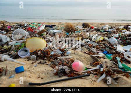 Koh Samui, Thailandia - 19 gennaio 2024: Spiaggia deserta, disseminata di bottiglie di plastica, imballaggi e altri rifiuti. Foto Stock