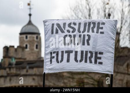 Londra, Regno Unito. 28 febbraio 2024. Gli attivisti per il clima della Extinction Rebellion (XR) si radunano a Tower Hill prima di marciare verso i Lloyd's di Londra per una giornata di "Insurance Mayhem", tentando di bloccare gli ingressi all'edificio mentre invitano l'industria a smettere di assicurare nuovi progetti di combustibili fossili. L'azione faceva parte di una settimana globale di eventi "assicurati il nostro futuro”, sperando di spingere l'industria a fare di più per combattere l'emergenza climatica. Crediti: Ron Fassbender/Alamy Live News Foto Stock