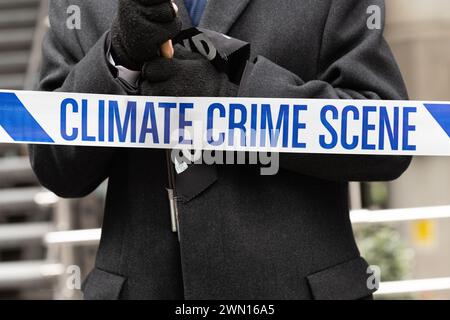 Londra, Regno Unito. 28 febbraio 2024. Gli attivisti per il clima della Extinction Rebellion (XR) si radunano a Tower Hill prima di marciare verso i Lloyd's di Londra per una giornata di "Insurance Mayhem", tentando di bloccare gli ingressi all'edificio mentre invitano l'industria a smettere di assicurare nuovi progetti di combustibili fossili. L'azione faceva parte di una settimana globale di eventi "assicurati il nostro futuro”, sperando di spingere l'industria a fare di più per combattere l'emergenza climatica. Crediti: Ron Fassbender/Alamy Live News Foto Stock