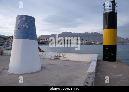 Una boa e una colonna su un molo vicino al bordo dell'acqua Foto Stock