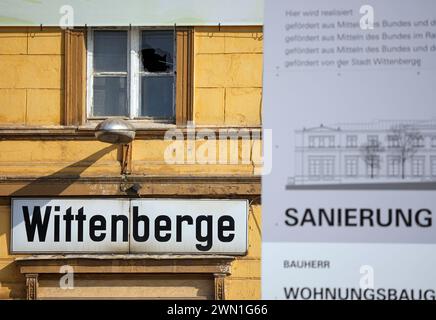 Wittenberge, Germania. 28 febbraio 2024. Un cartello con le parole "riqualificazione" si trova di fronte all'edificio della stazione di Wittenberge. La città sull'Elba, nella regione di Prignitz, diventerà la sede della prima accademia cittadina tedesca. La Small Town Academy è una piattaforma di networking e conoscenza a livello nazionale per le piccole città in Germania. L'ufficio si sposterà nelle stanze dell'edificio storico della stazione ferroviaria, che è attualmente in fase di ristrutturazione. Credito: Soeren Stache/dpa/Alamy Live News Foto Stock