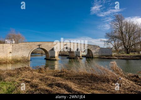 Milton Ferry Bridge, un vecchio ponte di pietra calcarea sul fiume Nene sul punto dell'inondazione nel febbraio 2024, Ferry Meadows, Peterborough, Inghilterra Foto Stock