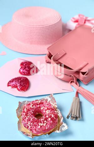 Composizione con accessori femminili e ciambella su sfondo colorato, primo piano. Festa di San Valentino Foto Stock