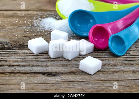 Ampia scelta di presentazioni di zucchero su un tavolo di legno, con cubetti di zucchero e zucchero granulato Foto Stock
