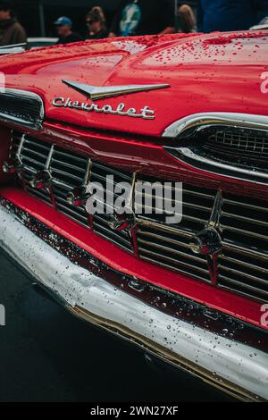 Thames, nuova Zelanda, 24 novembre 2022, Beach Hop Car Rally: Restored Vintage Red American Chevrolet con gocce di pioggia Foto Stock