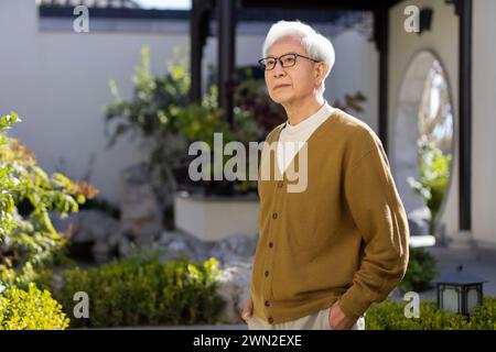 Uomo anziano nel giardino classico Foto Stock