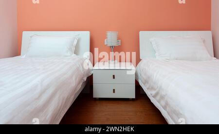 Due letti camera da letto con comodino e lampada Foto Stock