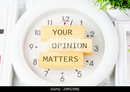 LA SUA OPINIONE CONTA UNA frase scritta sui blocchi di legno dell'orologio con le mani Foto Stock