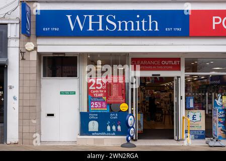 Fai shopping di fronte e accedi ad un negozio WH Smith in una strada inglese. Febbraio 2024. Foto Stock