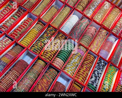 Braccialetti colorati indiani esposti in un negozio locale in un mercato di Pune, India, questi bellissimi braccialetti sono realizzati in vetro utilizzato come accessori di bellezza da in Foto Stock