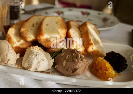 Pane tostato fritto su piatti con vari tipi di patatine sul tavolo della cucina al sole Foto Stock