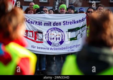 29 febbraio 2024, Sassonia-Anhalt, Halle (Saale): I dipendenti di Hallesche Verkehrs-AG (HAVAG) e i rappresentanti di Verdi e Fridays for Future si trovano di fronte a un deposito durante uno sciopero di allerta. Il sindacato Verdi aveva invitato i dipendenti del settore dei trasporti pubblici in diversi stati federali a fare uno sciopero di avvertimento nella disputa salariale nazionale in corso nei negoziati regionali. Foto: Jan Woitas/dpa Foto Stock