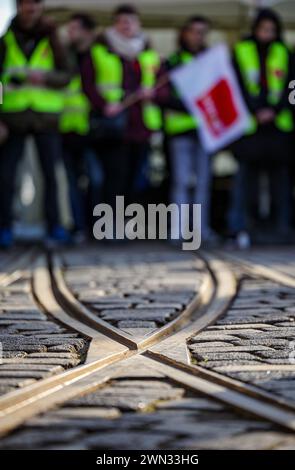 29 febbraio 2024, Sassonia-Anhalt, Halle (Saale): I dipendenti di Hallesche Verkehrs-AG (HAVAG) si trovano di fronte a un deposito durante uno sciopero di allerta. Il sindacato Verdi aveva invitato i dipendenti del settore dei trasporti pubblici in diversi stati federali a fare uno sciopero di avvertimento nella disputa salariale nazionale in corso nei negoziati regionali. Foto: Jan Woitas/dpa Foto Stock