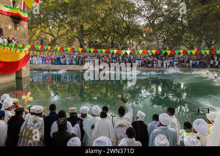 GONDAR, ETIOPIA - 19 GENNAIO 2019: Giovani che saltano nell'acqua Santa al festival Timkat a Fasilides Bath. Foto Stock