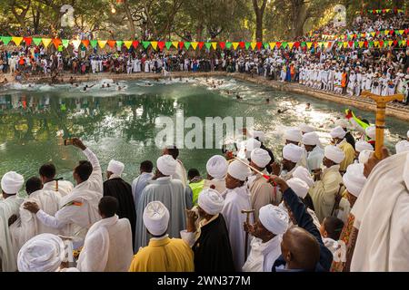 GONDAR, ETIOPIA - 19 GENNAIO 2019: Giovani che saltano nell'acqua Santa al festival Timkat a Fasilides Bath. Foto Stock