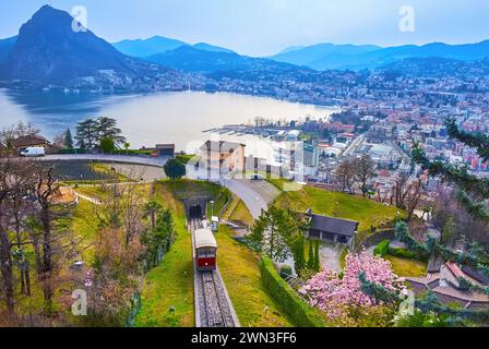 Il cielo notturno nuvoloso sul Monte San Salvatore, sul Lago di Lugano e sulla funicolare del Monte Bre, visto dal punto panoramico del paese di Albonago sul versante del Monte Bre, Foto Stock