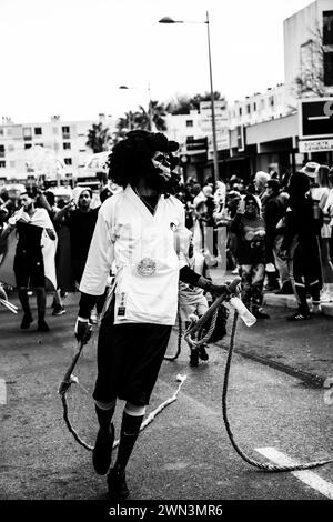 Le persone che passeggiano su una strada della città con cavalli al seguito di edifici, il Carnevale di Montpellier Foto Stock