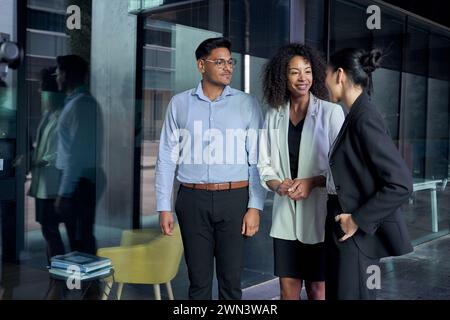 Team che incontra tre diversi professionisti ascoltando un leader asiatico irriconoscibile. Tuta per il personale di gruppo Foto Stock