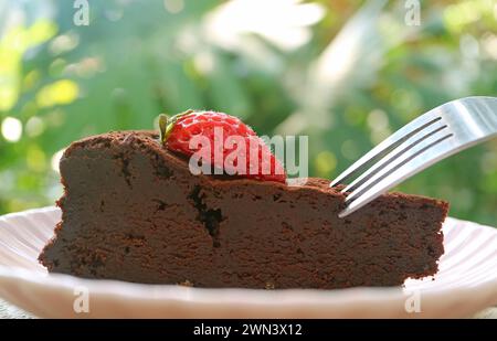 Primo piano della torta al cioccolato senza fiori umida e saporita con fragola fresca Foto Stock