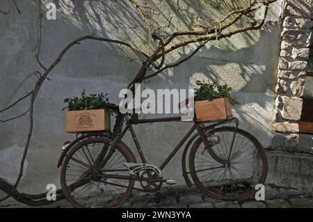 Vecchia bicicletta con casse di vino utilizzata come portabagagli all'esterno della casa nel quartiere medieviale di Confolens, in Francia Foto Stock