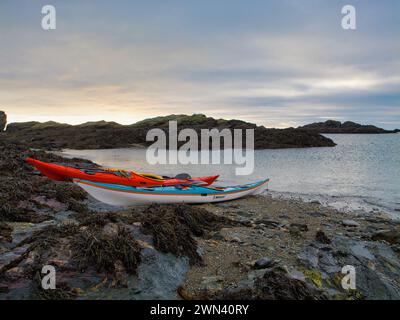 Anglesey, Regno Unito - 11 gennaio 2024: Due kayak da mare su una spiaggia deserta sull'isola di Anglesey nel Galles del Nord, Regno Unito. Preso in una giornata calma e coperto d'inverno. Foto Stock