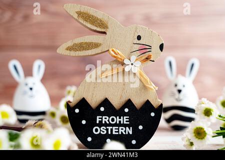 Augusta, Baviera, Germania - 28 febbraio 2024: Felice saluto pasquale su un coniglietto pasquale accanto alla decorazione di primavera *** Frohe Ostern Gruß auf einem Osterhase neben Frühlingsdekoration Foto Stock