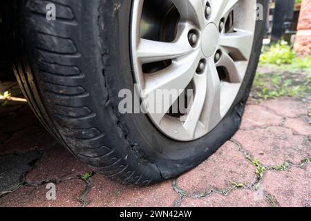 Primo piano dello pneumatico sgonfio per auto a causa della rottura sul lato della ruota Foto Stock