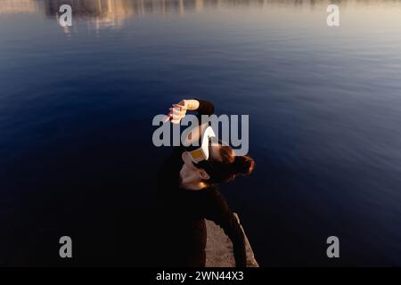 Young Woman utilizza occhiali per realtà virtuale o aumentata in un'atmosfera magica di raggi dell'alba, realtà virtuale femminile Foto Stock