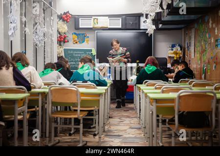 Charkiv, Ucraina. 19 dicembre 2023. L'insegnante si vede durante le lezioni con i bambini a scuola i bambini ucraini frequentano le lezioni in una scuola in una stazione della metropolitana di Charkiv, Ucraina, nel mezzo dell'invasione russa. Molti bambini a Charkiv non vanno a scuola perché i loro genitori temono per la loro sicurezza a causa della vicinanza della città al confine russo. Le autorità cittadine hanno organizzato il processo di istruzione per i bambini nelle classi della scuola sotterranea nella metropolitana della città. (Foto di Mykhaylo Palinchak/SOPA Images/Sipa USA) credito: SIPA USA/Alamy Live News Foto Stock