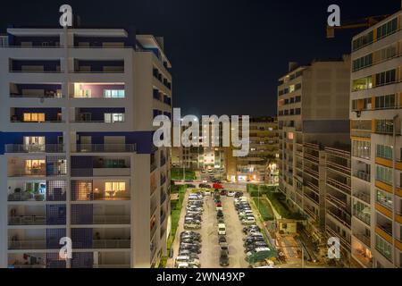 Finestre illuminate in blocchi di appartamenti di notte. Foto Stock