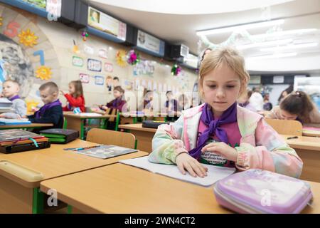 Charkiv, Ucraina. 19 dicembre 2023. Una giovane ragazza della sezione primaria viene vista durante le lezioni di classe a scuola. I bambini ucraini frequentano le lezioni in una scuola in una stazione della metropolitana di Charkiv, Ucraina, nel mezzo dell'invasione russa. Molti bambini a Charkiv non vanno a scuola perché i loro genitori temono per la loro sicurezza a causa della vicinanza della città al confine russo. Le autorità cittadine hanno organizzato il processo di istruzione per i bambini nelle classi della scuola sotterranea nella metropolitana della città. Credito: SOPA Images Limited/Alamy Live News Foto Stock