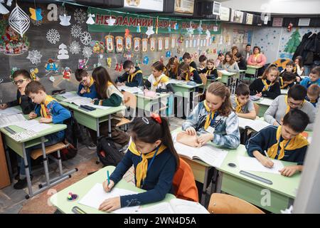 Charkiv, Ucraina. 19 dicembre 2023. I bambini vengono visti durante le lezioni di classe a scuola. I bambini ucraini frequentano le lezioni in una scuola in una stazione della metropolitana di Charkiv, Ucraina, nel mezzo dell'invasione russa. Molti bambini a Charkiv non vanno a scuola perché i loro genitori temono per la loro sicurezza a causa della vicinanza della città al confine russo. Le autorità cittadine hanno organizzato il processo di istruzione per i bambini nelle classi della scuola sotterranea nella metropolitana della città. Credito: SOPA Images Limited/Alamy Live News Foto Stock