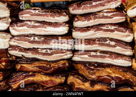 Pancetta esposta e carne secca prodotti domestici presentati per la vendita sul mercato agricolo del villaggio di Kacarevo, bacon gastro e festival dei prodotti a base di carne secca Foto Stock