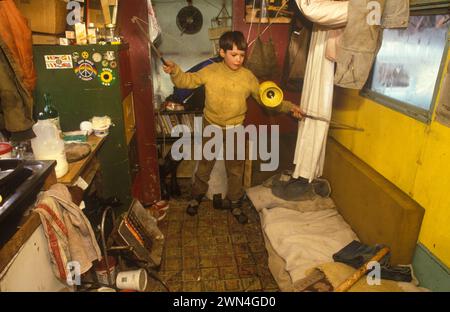 OFF Grid Living 1980s UK. Bambino, giovane ragazzo nell'ufficio del padre, un camper. Kevin Oubridge viveva con la sua famiglia nella valle di tipi, una comunità hippy gallese che ospitava circa 120 spiriti liberi eco-compatibili. Llandeilo, Galles 1985 HOMER SYKES Foto Stock