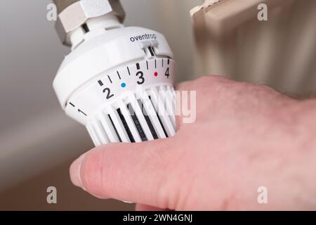Mano su una valvola del radiatore Foto Stock