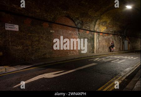 Bermondsey, Londra, Regno Unito: Shand Street che passa attraverso un tunnel stradale sotto il London Bridge fino al Greenwich Railway Viaduct Foto Stock