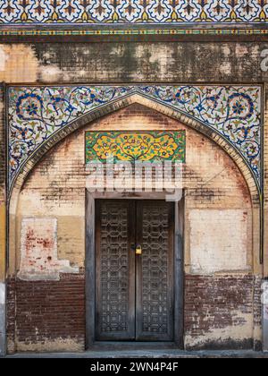 Una porta di legno presso il monumento storico Masjid Wazir Khan, una moschea moghul del XVII secolo situata nella città di Lahore, Punjab, Pakistan. Foto Stock