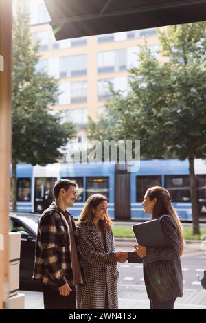 Felice coppia saluto agente immobiliare donna Foto Stock